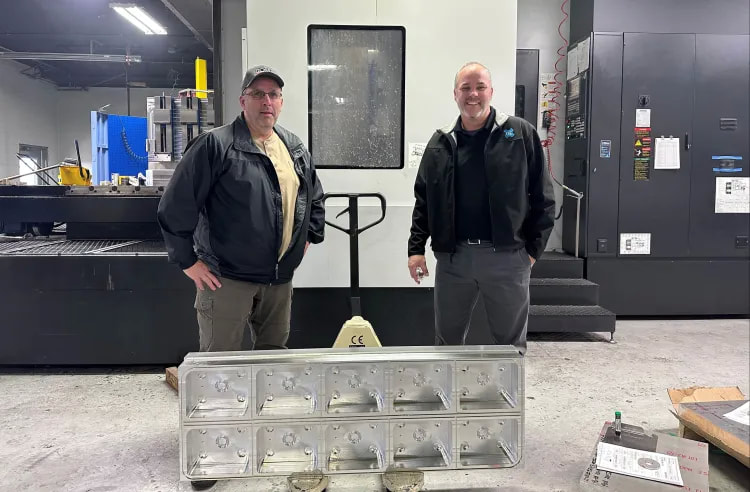 From left, Ross Industries Machine Shop Manager Greg Williams and OSG USA Territory Sales Manager Frank Twomey pose for a photograph with a completed upper chamber.